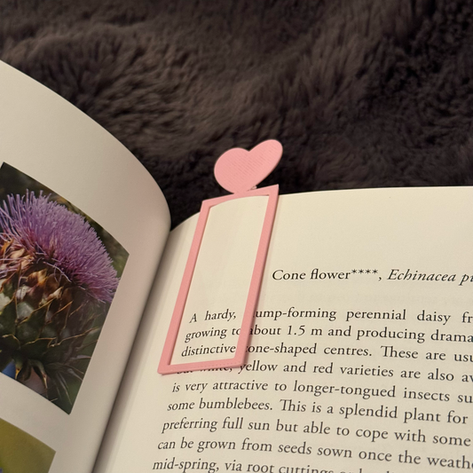 Pink heart-shaped bookmark on an open book with a fur background