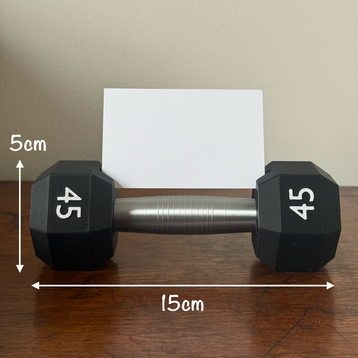 Dumbbell shape design business card holder with a plain background on a wooden surface measurements 