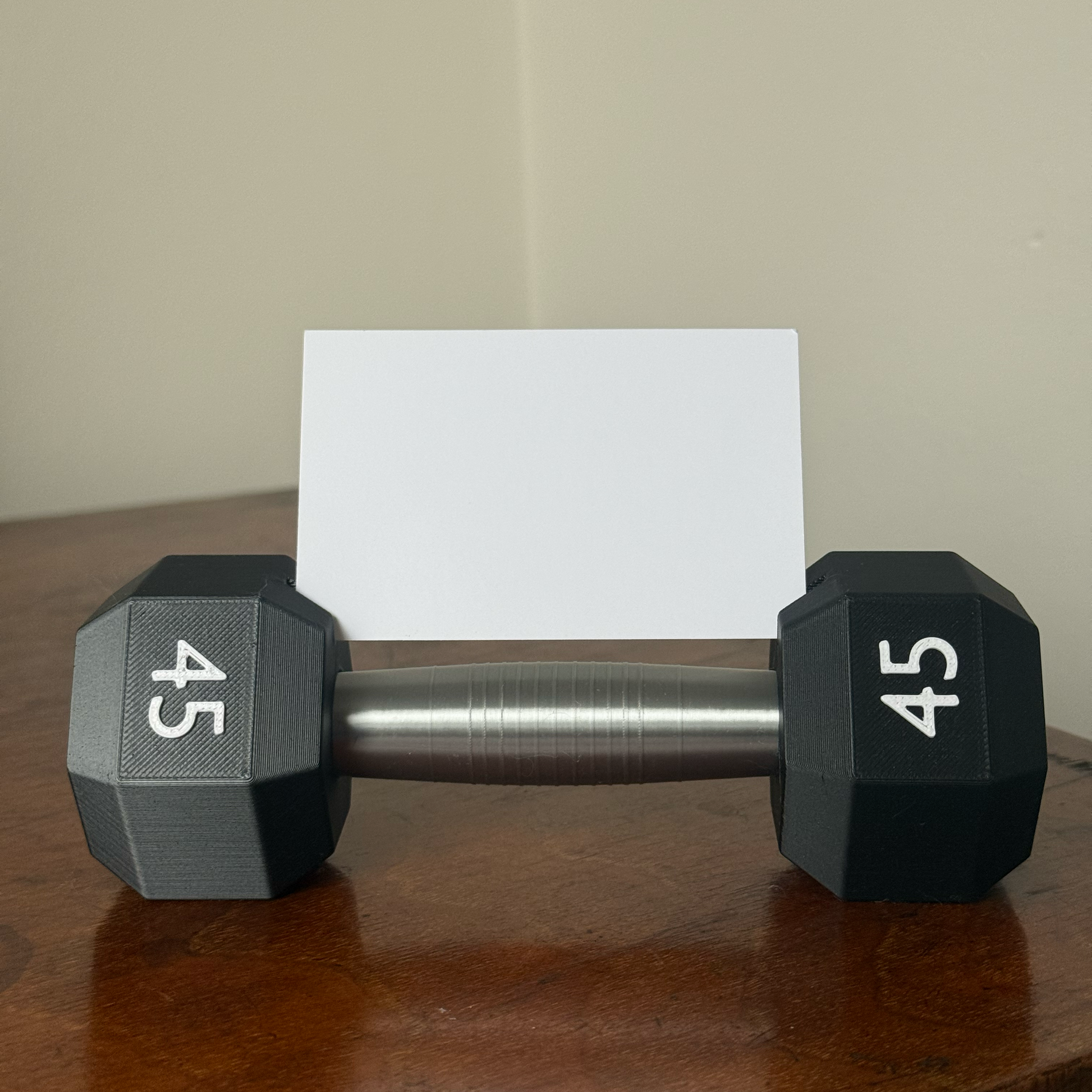 Dumbbell shape design business card holder with a plain background on a wooden surface