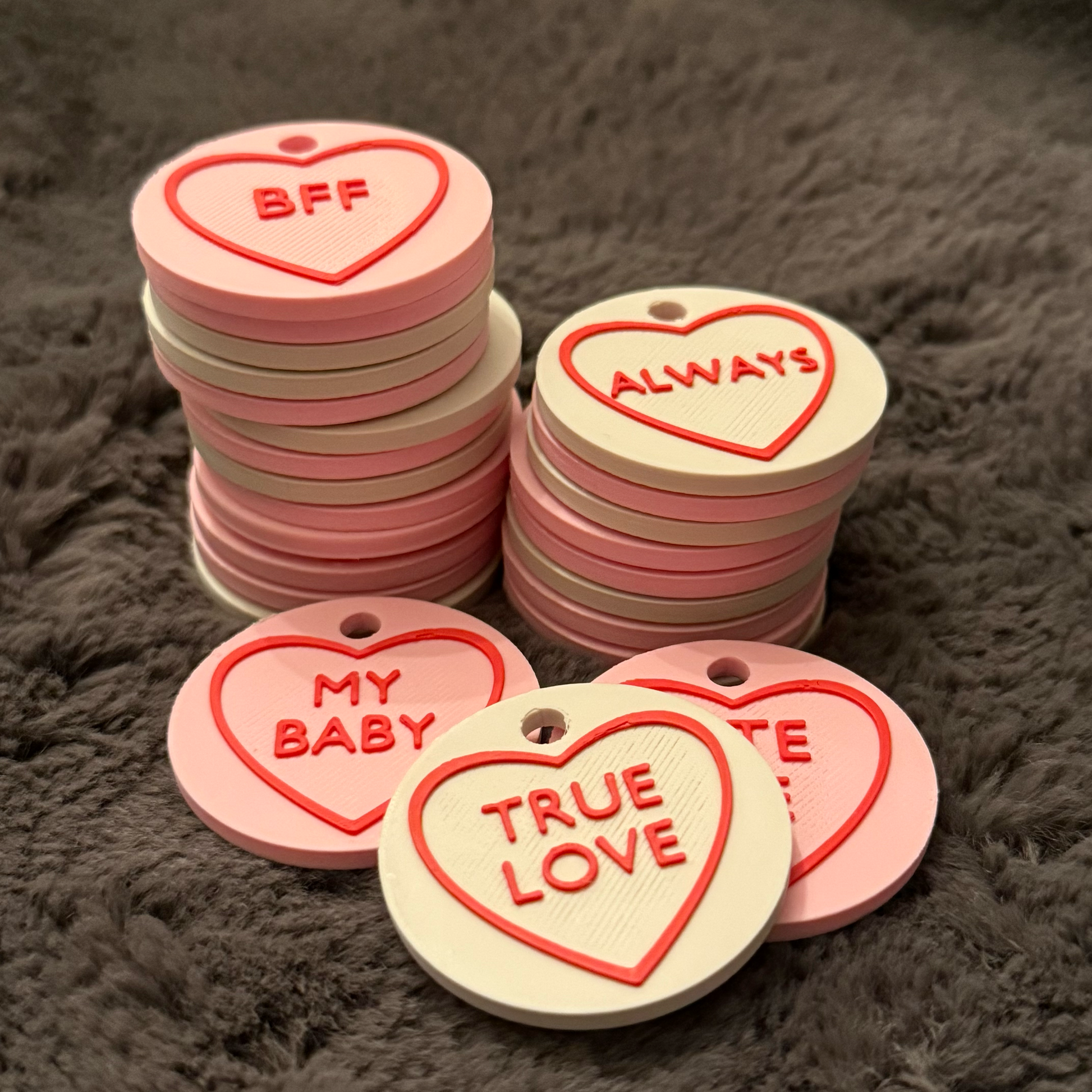 Heart-shaped tags with romantic phrases on a textured surface