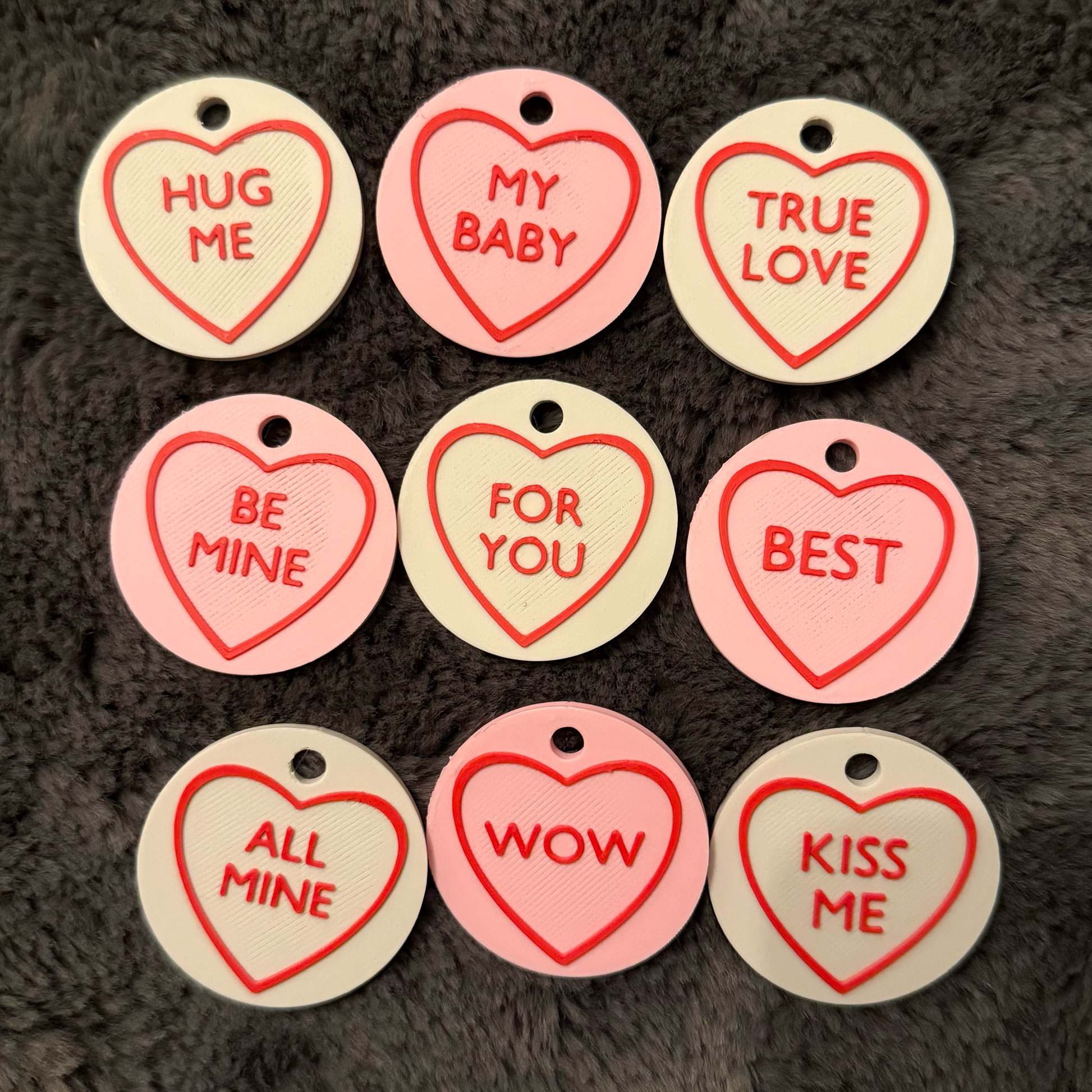 Heart-shaped tags with romantic phrases on a textured surface