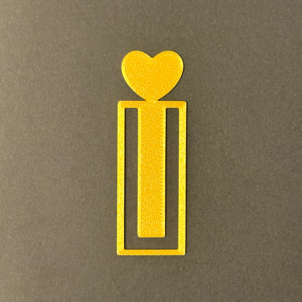 Decorative gold bookmark with heart designs on a fluffy soft surface