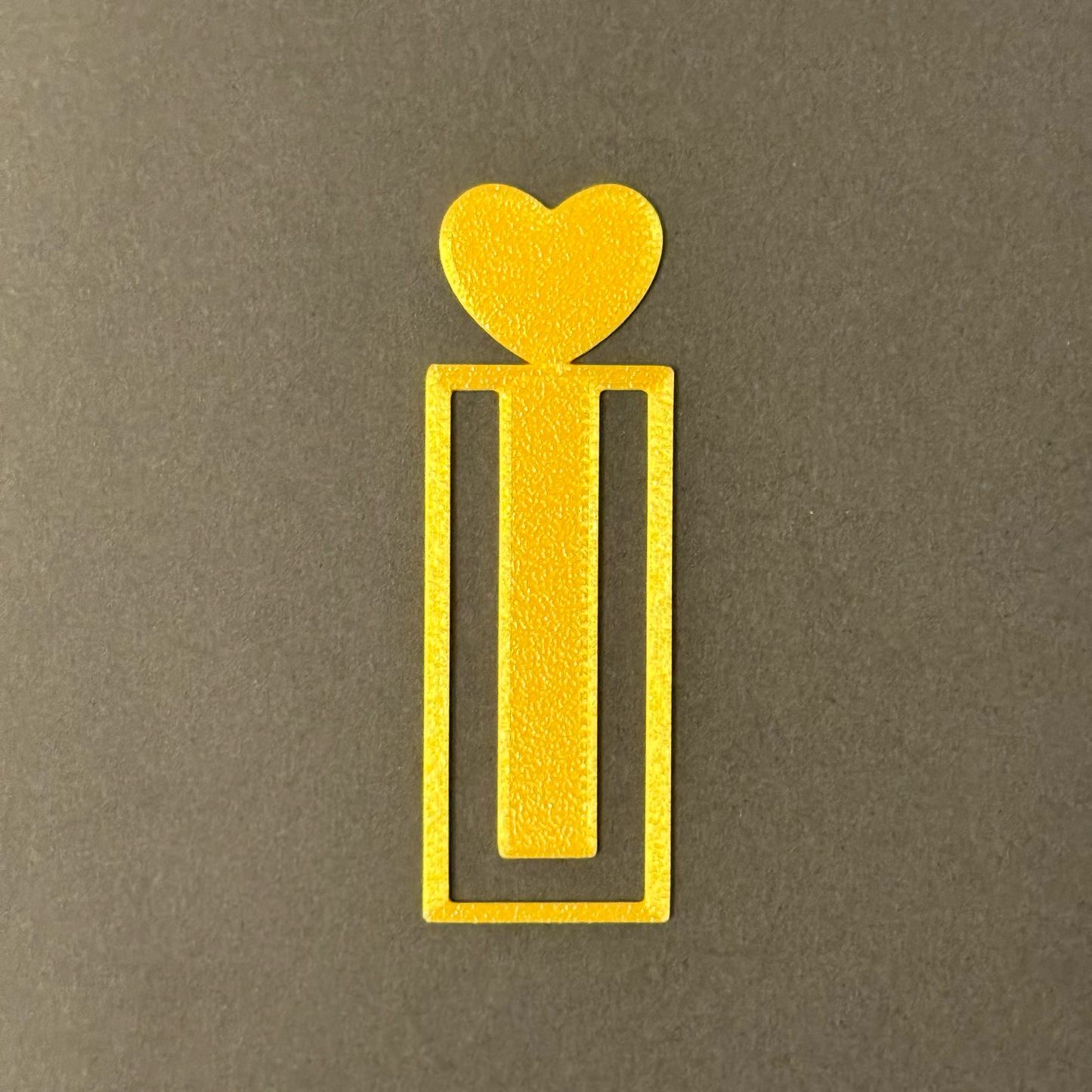 Decorative gold bookmark with heart designs on a fluffy soft surface