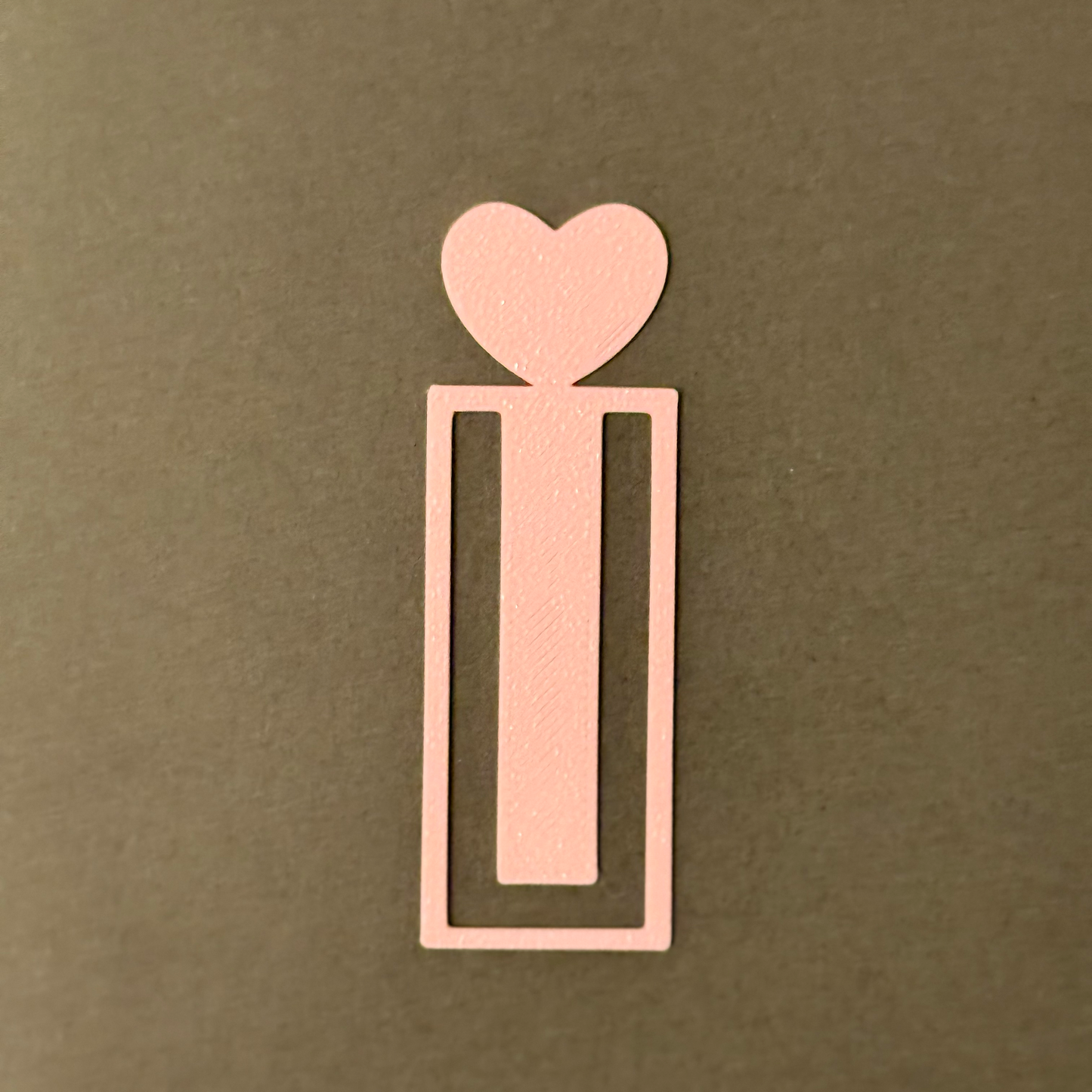 Decorative pink bookmark with heart designs on a fluffy soft surface