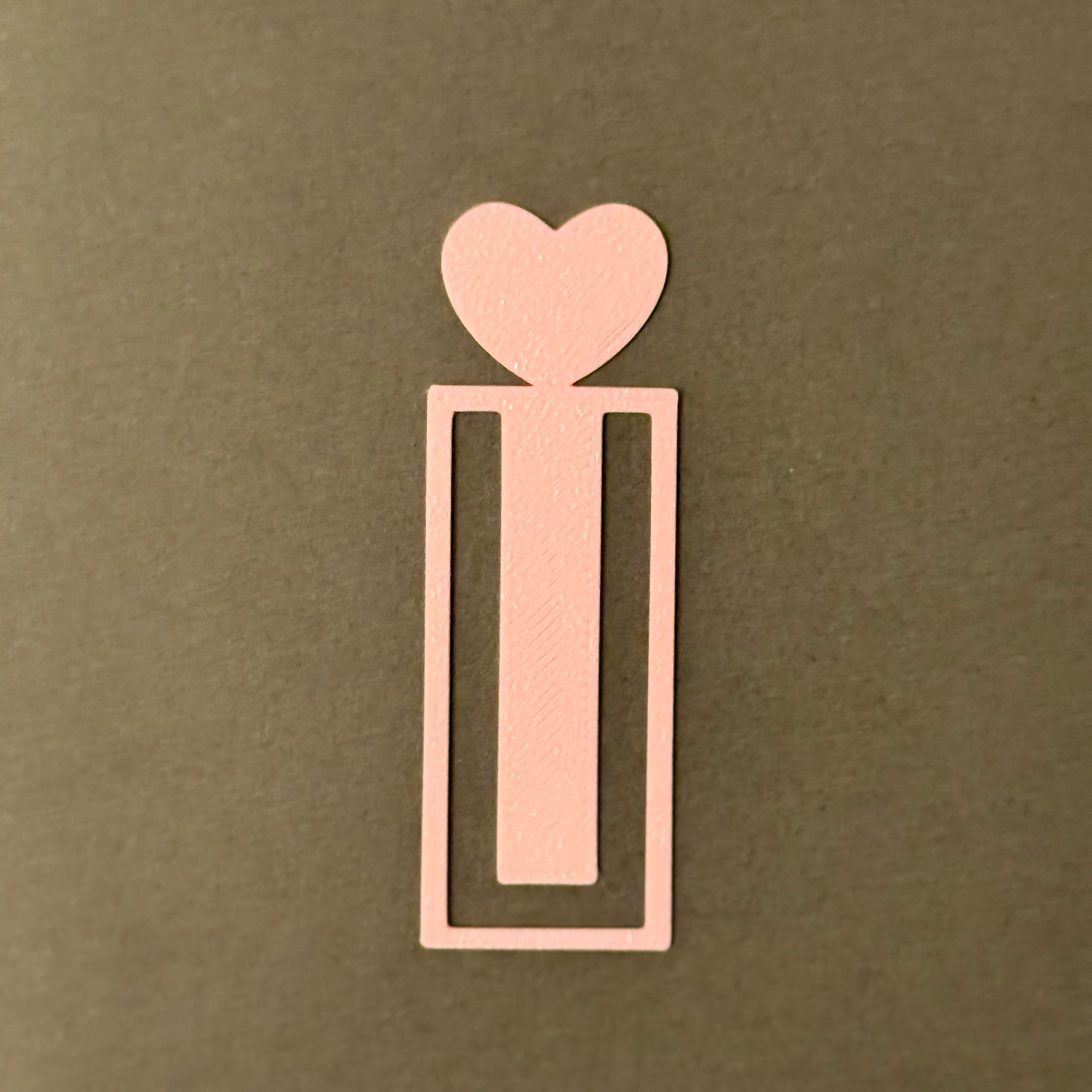 Decorative pink bookmark with heart designs on a fluffy soft surface